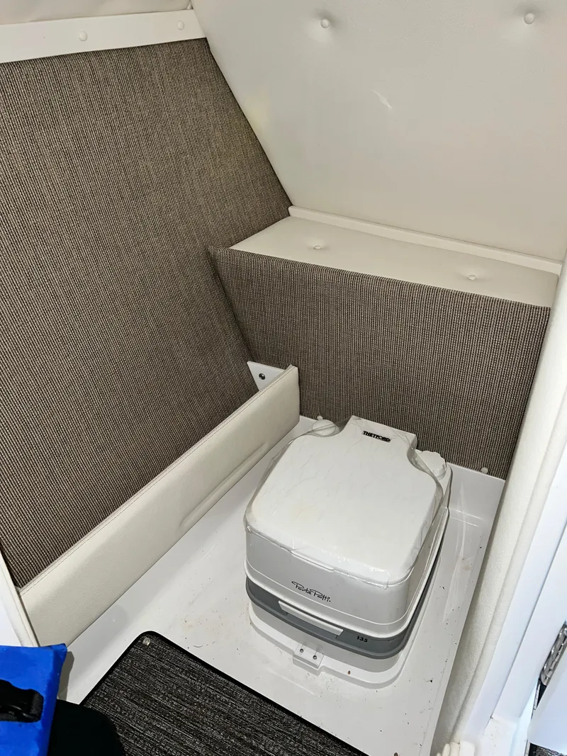 Slide: The Image of 2021 Cobalt R5 boat interior with portable toilet in cabin. - 25