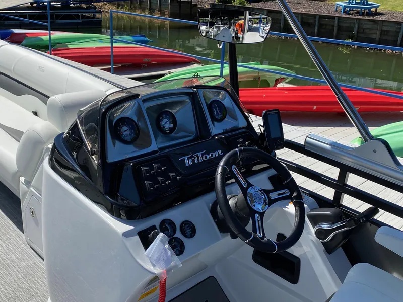 Slide: The Image of 2023 JC Neptoon Sport 23TT boat dashboard with steering wheel and control panel. - 15