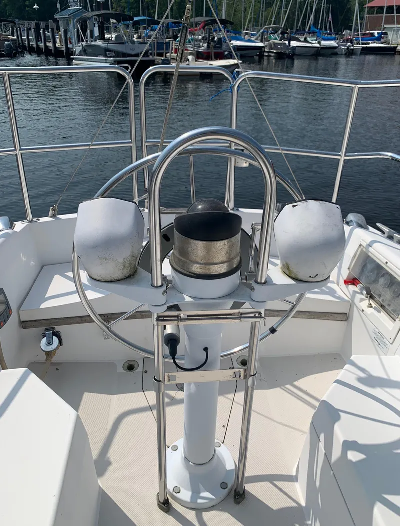 Slide: The Image of 1987 Catalina 30 Tall-Rig sailboat helm with marina background. - 12