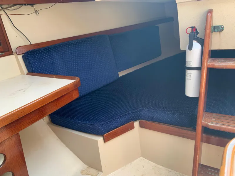 Slide: The Image of Interior cabin of a 1987 Catalina 30 Tall-Rig sailboat with blue cushions and a fire extinguisher. - 34