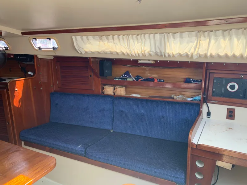 Slide: The Image of Interior of 1987 Catalina 30 Tall-Rig sailboat with blue cushioned seating. - 39