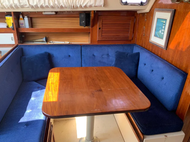 Slide: The Image of Cozy dining area in a 1987 Catalina 30 Tall-Rig sailboat with blue cushioned seating. - 47