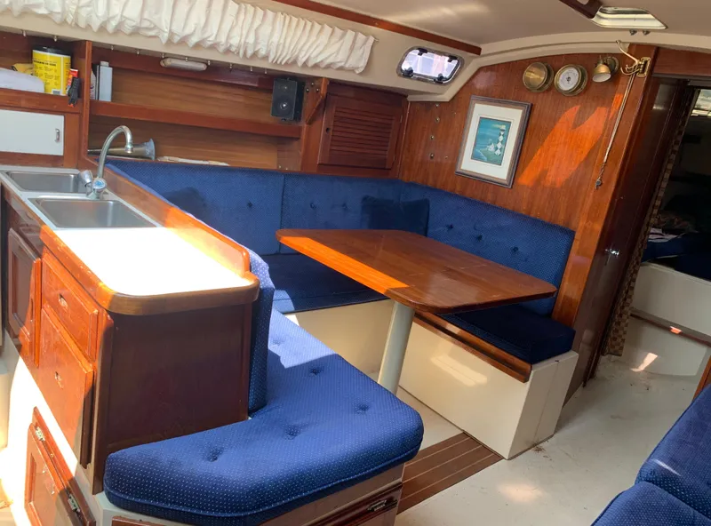 Slide: The Image of Interior of 1987 Catalina 30 Tall-Rig sailboat with blue upholstery and wooden table. - 48