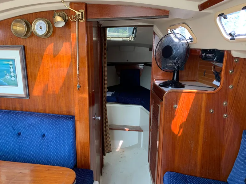 Slide: The Image of Interior of 1987 Catalina 30 Tall-Rig sailboat with wood paneling and blue upholstery. - 49