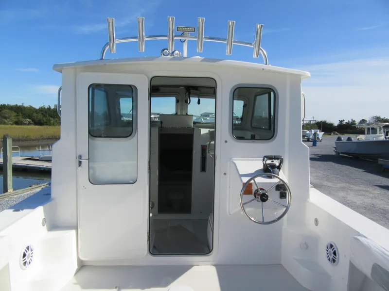 Slide: The Image of 2024 Parker 2820 XLD Sport Cabin boat with open cabin door and steering wheel. - 9