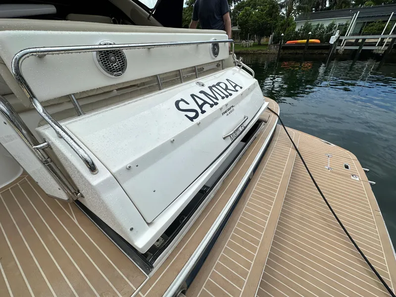 Slide: The Image of 2007 Regal 4460 Commodore yacht docked, showing the rear deck and boat name SAMRA. - 23