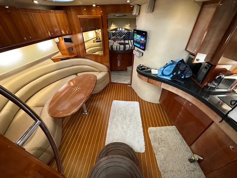 Slide: The Image of 2007 Regal 4460 Commodore yacht interior with wood finishes, curved seating, and modern amenities. - 33