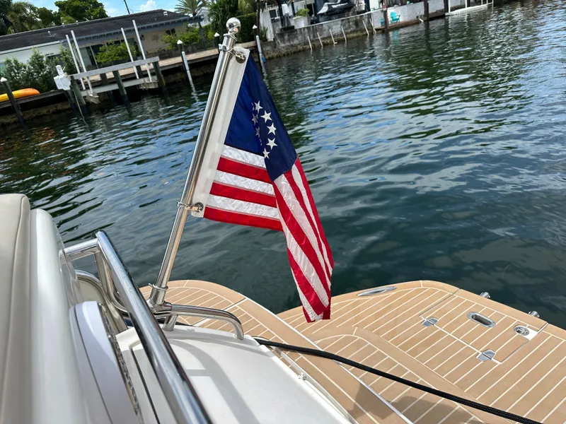 Slide: The Image of 2007 Regal 4460 Commodore boat with American flag on water. - 49