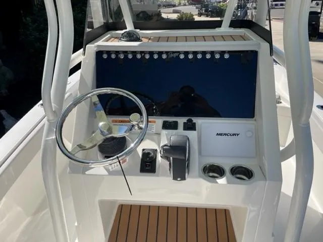 Slide: The Image of 2024 Ranger 2510 Bay boat console with steering wheel and Mercury controls. - 2
