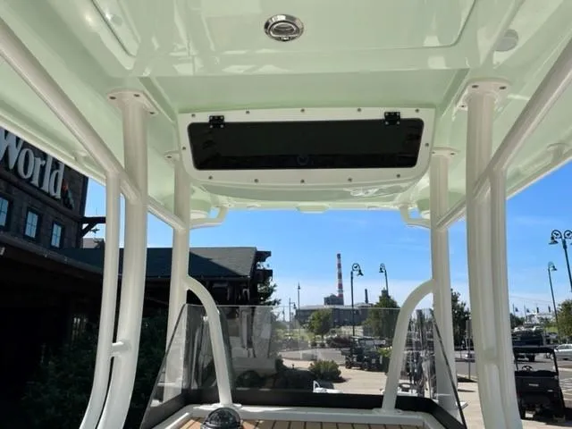 Slide: The Image of 2024 Ranger 2510 Bay boat interior with T-top and cityscape background. - 4