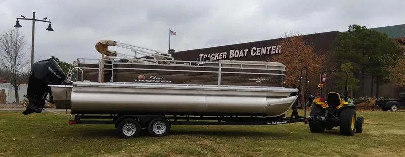 Slide: The Image of 2024 Sun Tracker SportFish 22 XP3 pontoon boat on trailer outside Tracker Boat Center. - 2