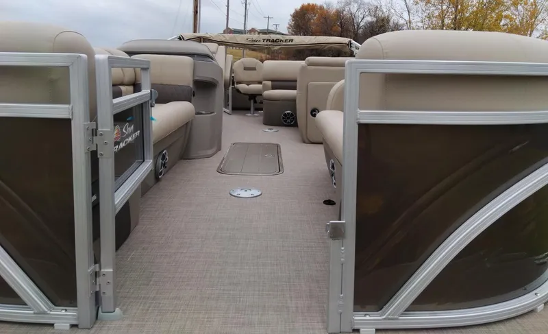 Slide: The Image of 2024 Sun Tracker SportFish 22 XP3 pontoon boat interior with beige seating and open deck. - 3