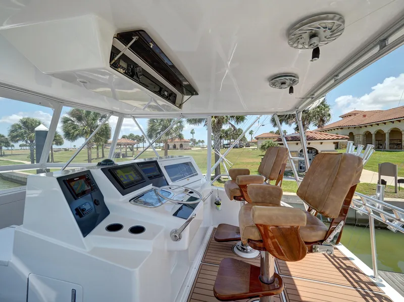 Slide: The Image of 2001 Viking Convertible yacht helm station with leather captain chairs and advanced navigation systems. - 24
