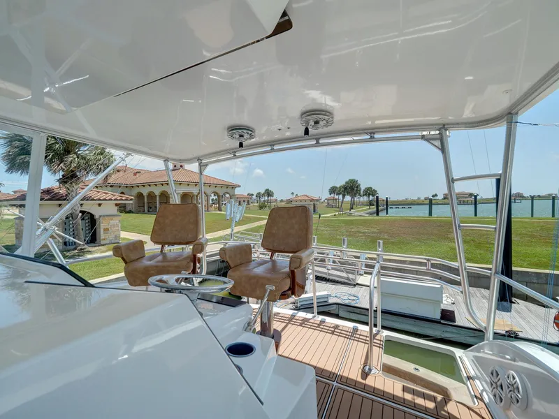 Slide: The Image of 2001 Viking Convertible yacht with helm chairs and scenic marina view. - 29