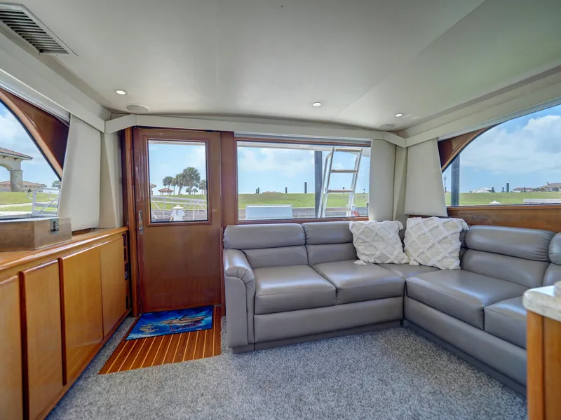 Slide: The Image of Interior of 2001 Viking Convertible yacht with gray leather sectional sofa and large windows. - 6