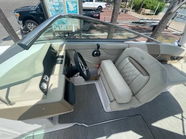 Slide: The Image of 2016 Regal 26 Fastdeck boat cockpit with steering wheel and beige seating. - 10