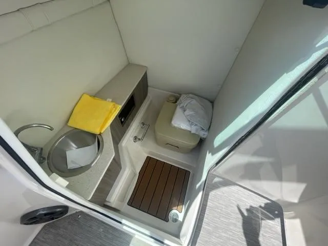 Slide: The Image of 2016 Regal 26 Fastdeck boat interior with sink, toilet, and storage. - 13