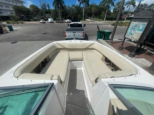 Slide: The Image of 2016 Regal 26 Fastdeck boat interior with beige seating at a dock. - 14