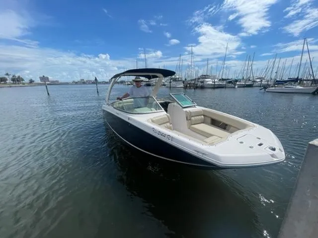 Slide: The Image of 2016 Regal 26 Fastdeck boat on water near marina with blue sky. - 2
