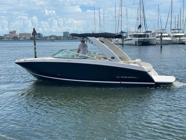 Slide: The Image of 2016 Regal 26 Fastdeck boat cruising in a marina with sailboats in the background. - 21