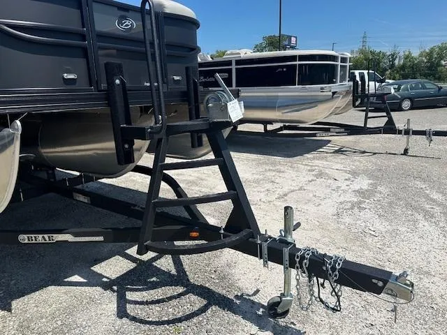 Slide: The Image of 2024 Barletta C24QC pontoon boat on a trailer in a parking lot. - 2