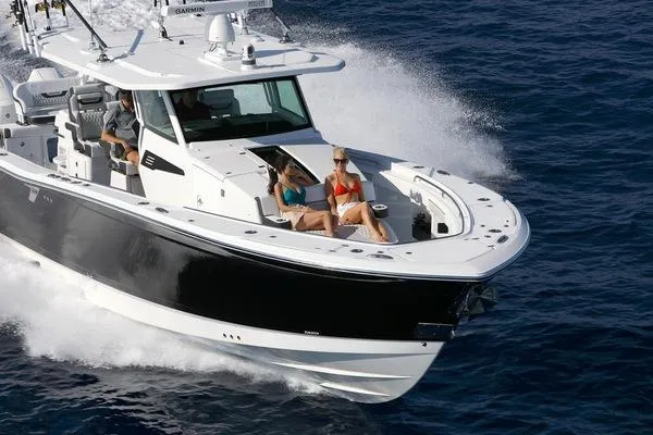 Slide: The Image of 2024 Blackfin 400 CC cruising on the ocean with passengers relaxing on deck. - 2