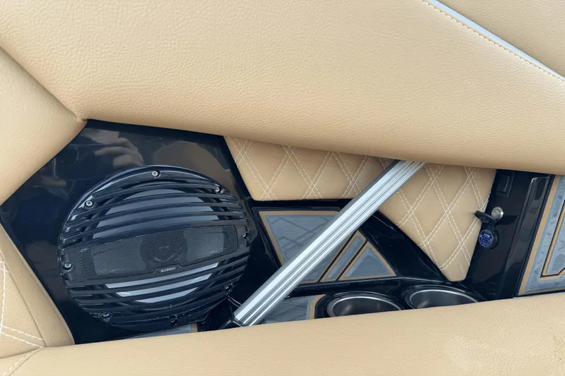 Slide: The Image of 2024 Tigé RZX22 boat interior with tan leather seats and built-in Audison speaker. - 15