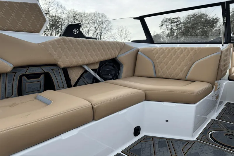 Slide: The Image of 2024 Tigé RZX22 boat interior with tan diamond-stitched upholstery and modern design. - 16