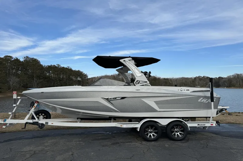 Slide: The Image of 2024 Tigé RZX22 boat on trailer by a lake, featuring sleek design and modern amenities. - 4