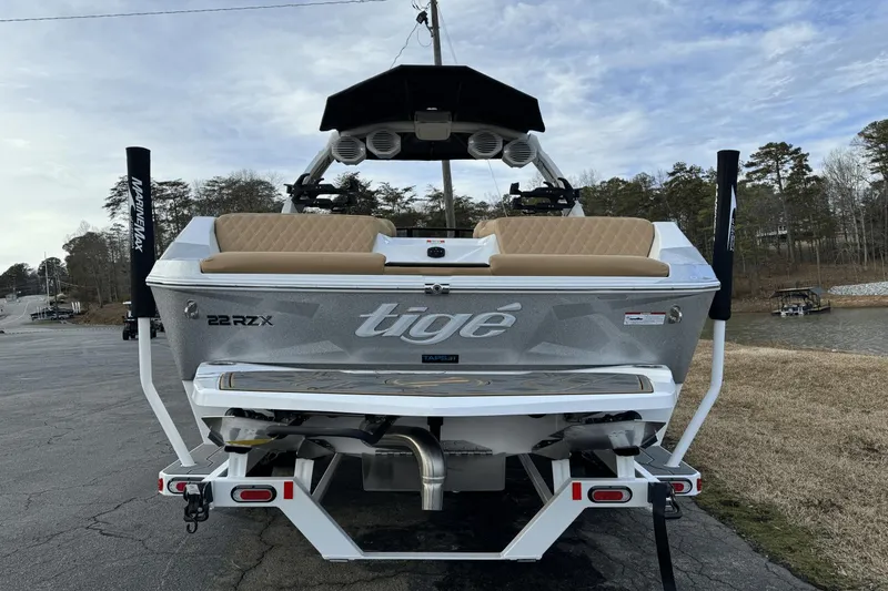 Slide: The Image of 2024 Tigé RZX22 boat rear view with tan seats and speakers. - 7