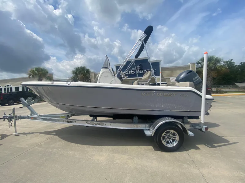 Slide: The Image of 2024 Key West 189 FS boat on trailer at dealership under cloudy sky. - 0