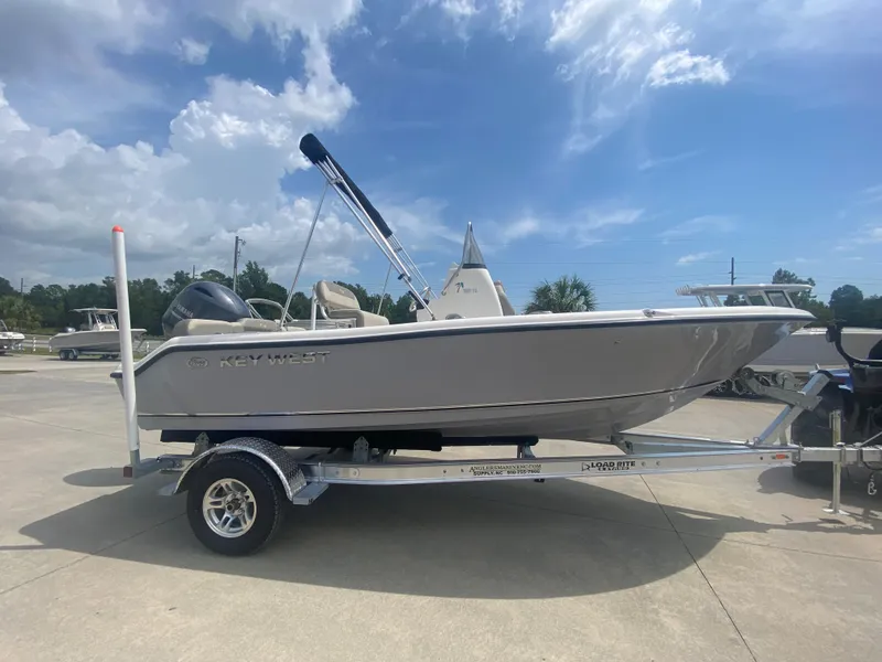 Slide: The Image of 2024 Key West 189 FS boat on a trailer under a partly cloudy sky. - 2