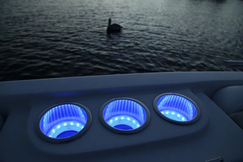Slide: The Image of 2024 Starcraft SVX 231 OB DH boat with illuminated cup holders at dusk. - 11