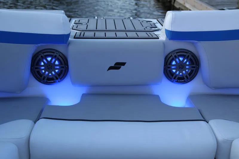 Slide: The Image of 2024 Starcraft SVX 231 OB DH boat interior with blue LED lighting and speakers. - 8