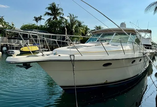 The Image of 1996 Tiara Yachts 3500 Express docked in a tropical marina. - 0