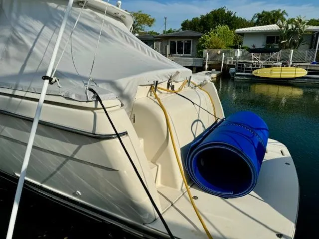 Slide: The Image of 1996 Tiara Yachts 3500 Express docked with blue hose on deck. - 10