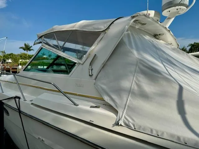 Slide: The Image of 1996 Tiara Yachts 3500 Express boat docked with white canvas cover. - 11