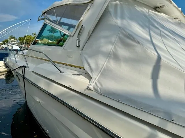 Slide: The Image of 1996 Tiara Yachts 3500 Express boat docked, side view with white canvas cover. - 12