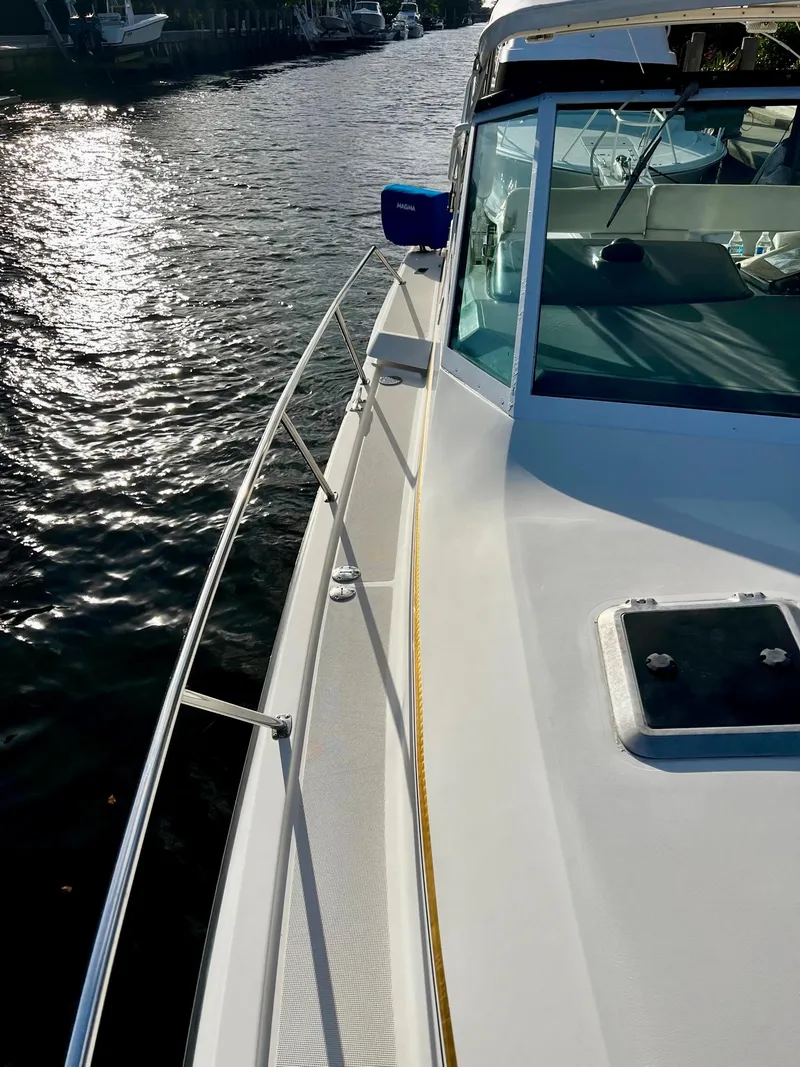 Slide: The Image of 1996 Tiara Yachts 3500 Express on water, side deck view. - 13