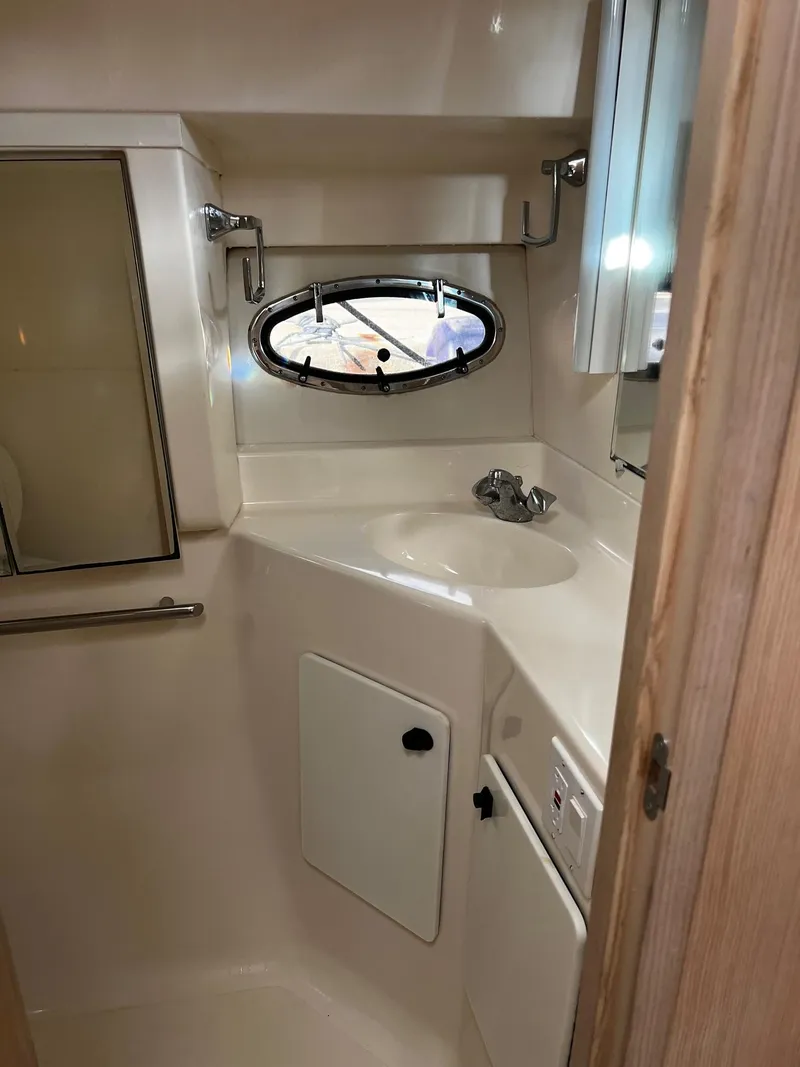 Slide: The Image of 1996 Tiara Yachts 3500 Express bathroom with sink and porthole window. - 19