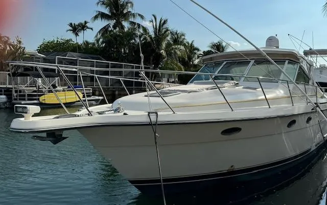 Slide: The Image of 1996 Tiara Yachts 3500 Express docked near palm trees. - 2