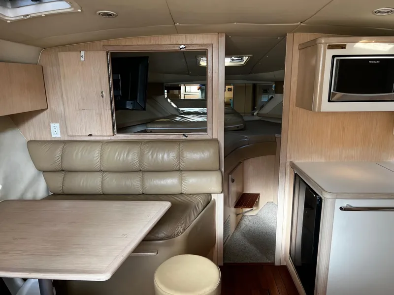 Slide: The Image of 1996 Tiara Yachts 3500 Express interior with dining area, kitchenette, and sleeping quarters. - 24