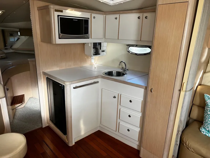 Slide: The Image of 1996 Tiara Yachts 3500 Express kitchen with microwave, sink, and storage cabinets. - 25