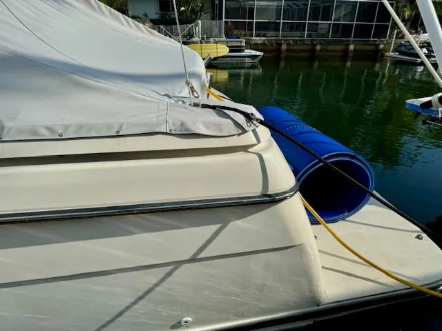 Slide: The Image of 1996 Tiara Yachts 3500 Express docked with cover and blue fender. - 27