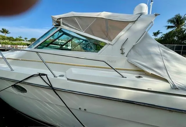 Slide: The Image of 1996 Tiara Yachts 3500 Express boat docked, side view with canopy. - 5