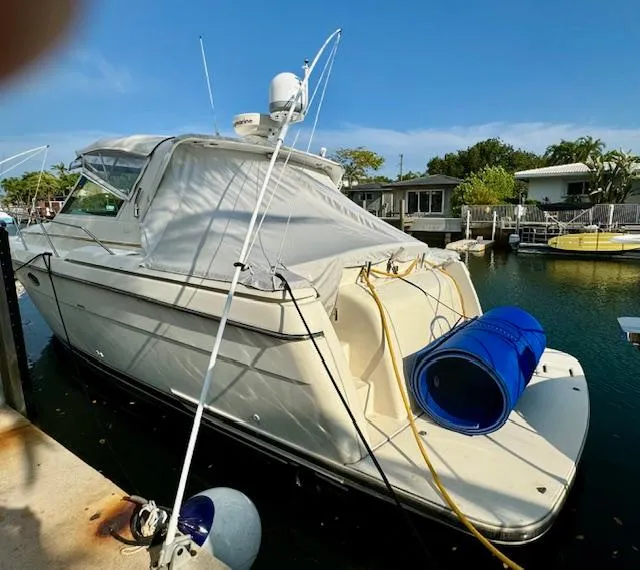 Slide: The Image of 1996 Tiara Yachts 3500 Express docked at marina, rear view with blue barrel. - 8