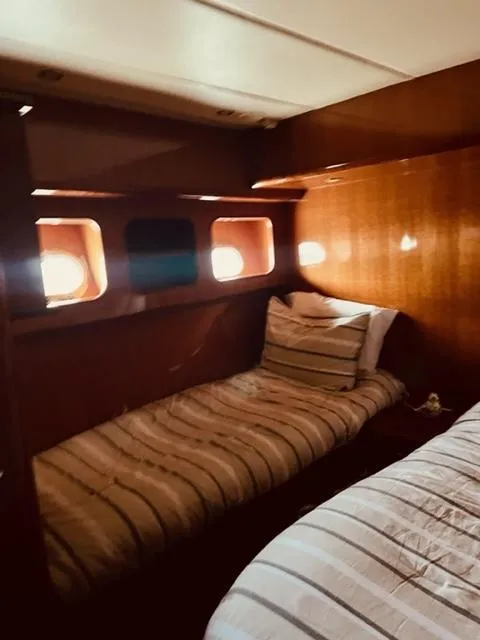 Slide: The Image of 2008 Hampton Command Bridge yacht cabin with twin beds and wooden interior. - 10