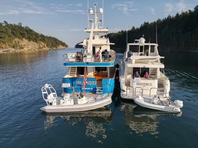 Slide: The Image of Two Hampton Command Bridge yachts, 2008 model, docked together in a scenic coastal area. - 21