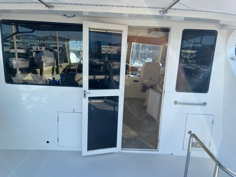 Slide: The Image of 2008 Hampton Command Bridge yacht with open door, showing interior and marina background. - 42