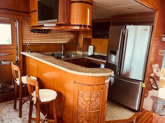 Slide: The Image of Luxurious kitchen in a 2008 Hampton Command Bridge yacht with modern appliances and wooden cabinetry. - 6